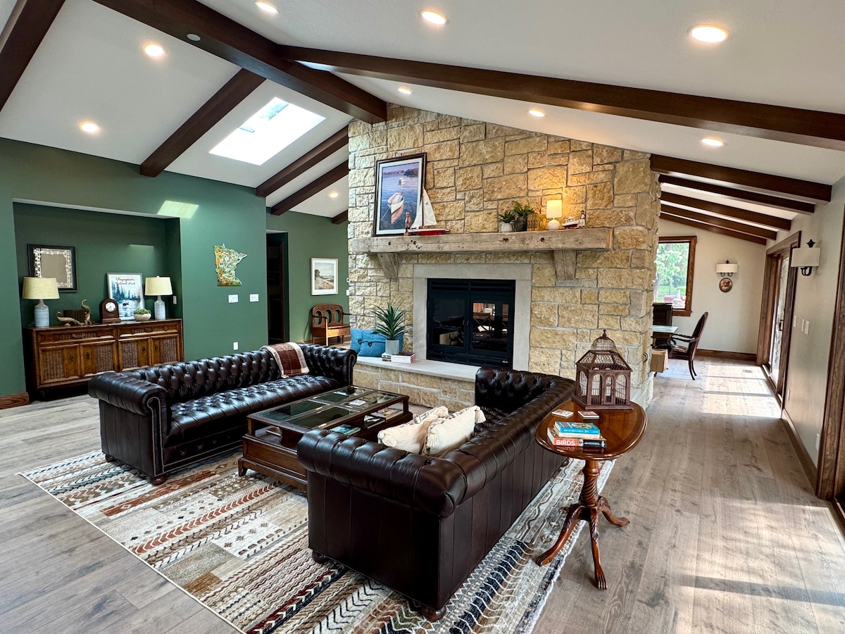 Spacious great room with stone fireplace and river-facing windows