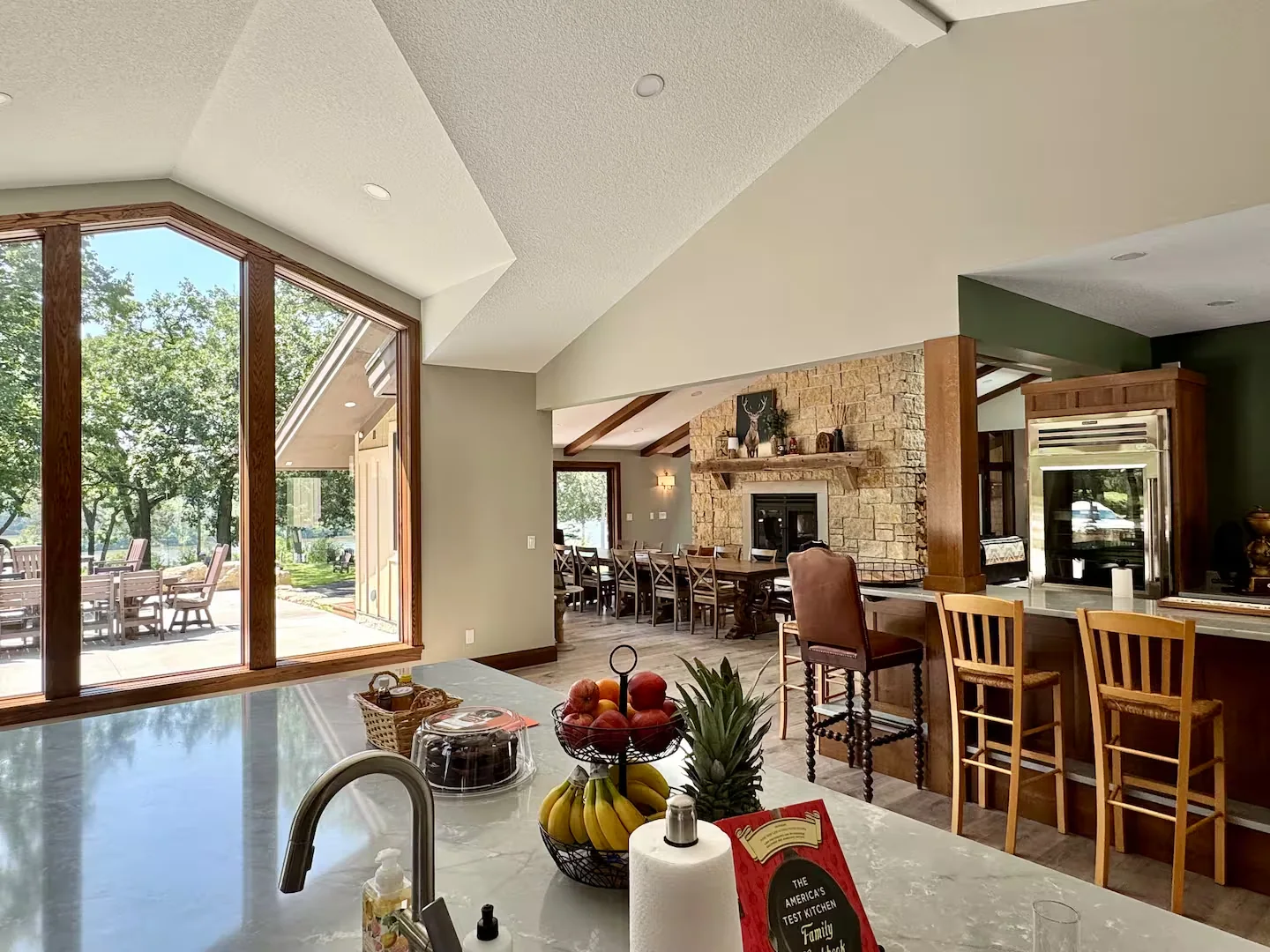 The great room with stone fireplace and large river-facing windows